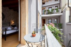 a small balcony with a table and a bed at Residence "Professor's nest" - Verona Apartments in Verona