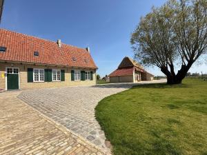 a house with a tree and a brick driveway at Eikenbrand in Veurne