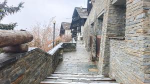 een oude stenen steeg met trappen in een oud gebouw bij Hostdomus - Betulle Apartments in Sestriere