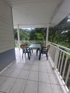 un patio con tavolo e sedie su un balcone di La maison du sud a Rivière-Salée Altre 8 foto