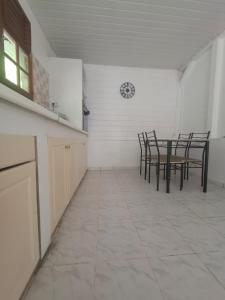 una cucina con sedie e tavolo e un orologio sul muro di La maison du sud a Rivière-Salée