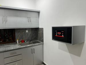 a kitchen with a sink and a microwave at Kaarasaaram inn in Avarankal +3 photos
