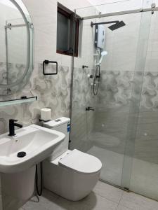 a bathroom with a toilet and a sink and a shower at Kaarasaaram inn in Avarankal