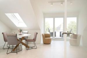a white dining room with a table and chairs at Dahmer Strand 5 in Dahme