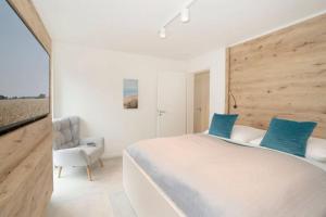 a bedroom with a large bed and a chair at Dahmer Strand 5 in Dahme