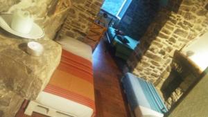 Cette chambre dispose d'un mur en pierre, d'un lit et d'une cheminée. dans l'établissement B&B Da Marta, à Apricale