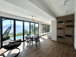 a living room with a swing and a table and chairs at Bella Vista Rezidence in Pogradec