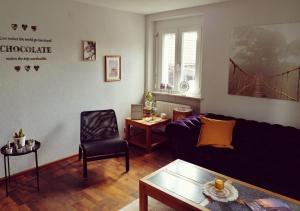 een woonkamer met een bank en een stoel bij Ferienwohnung Südschwarzwald in Wehr