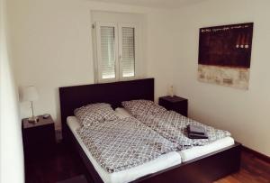 een bed in een slaapkamer met 2 nachtkastjes en 2 lampen bij Ferienwohnung Südschwarzwald in Wehr