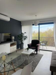 een woonkamer met een bank en een tv bij Balcón Andino in Maipú