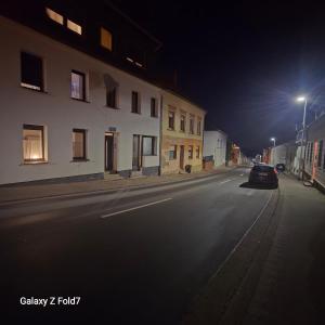 een lege straat 's nachts met een auto geparkeerd op de weg bij Ferienwohnung in Bexbach