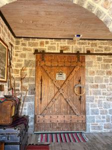 a large wooden door on a brick wall at Villa Naum in Voskopojë