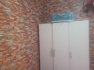 a brick wall with a white cabinet and a door at بيت مع وجبة إفطار لمشجعي كأس الأمم الأفريقية in Fez