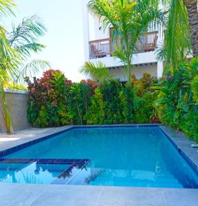 a swimming pool in front of a house with trees at Bustan in Matemwe +32 photos