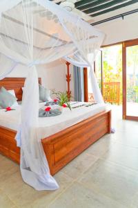 a bedroom with a bed with a mosquito net at Bustan in Matemwe