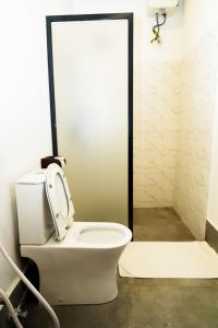 a bathroom with a toilet with the lid up at Bustan in Matemwe