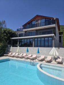 a swimming pool with lounge chairs and a building at Bella Vista Rezidence in Pogradec