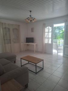 un soggiorno con un divano e un tavolo di La maison du sud a Rivière-Salée