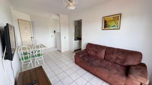 een woonkamer met een bruine bank en een tafel bij Apartamentos Aquarius Flat in Caldas Novas