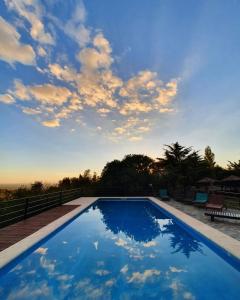 een groot blauw zwembad met een bewolkte hemel bij Hostería Vegetariana in Country Club Chumamaya