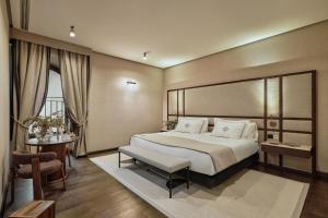 a bedroom with a large bed and a table at Hospes Palacio del Bailio, a Member of Design Hotels in Córdoba +54 photos