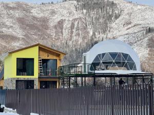a building with a dome on top of it in front of a mountain at Buddy glamping Borjomi in Borjomi
