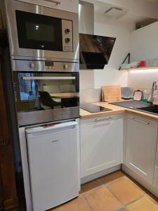 eine Küche mit Herd und Mikrowelle in der Unterkunft Studio 2 personnes proche du Futuroscope in Beaumont