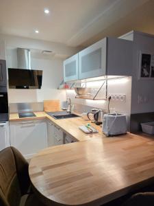 eine Küche mit einem Holztisch und einer Arbeitsplatte in der Unterkunft Studio 2 personnes proche du Futuroscope in Beaumont