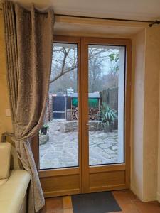 eine Glasschiebetür mit Blick auf einen Hof in der Unterkunft Studio 2 personnes proche du Futuroscope in Beaumont