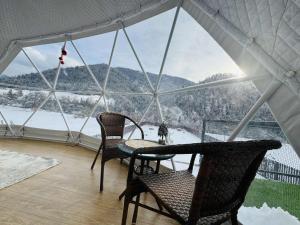 a room with two chairs and a table and a window at Buddy glamping Borjomi in Borjomi