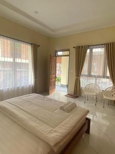 - une chambre avec un grand lit, 2 chaises et des fenêtres dans l'établissement SADAMA Cottage, à Tuk Tuk