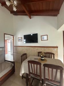 a dining room with a table and chairs and a tv at Casa in Villa Gesell