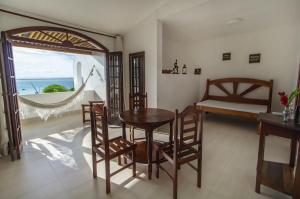 une salle à manger avec une table et des chaises et une fenêtre dans l'établissement Pousada Natureza, à Morro de São Paulo
