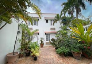 een wit huis met planten ervoor bij At Wind Chimes Boutique Hotel in San Juan