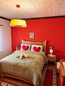 a bedroom with red walls and a large bed at Villa Naum in Voskopojë