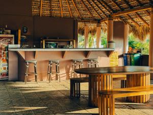 een bar met houten tafels en krukken in een restaurant bij Viajero Puerto Escondido Hostel in Puerto Escondido