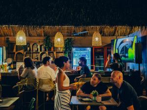 een groep mensen die aan een bar zitten bij Viajero Puerto Escondido Hostel in Puerto Escondido