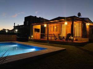 une petite maison avec une piscine en face de celle-ci dans l'établissement El Refugio del Lago en Potrero de Garay, à La Estancia 5 autres photos