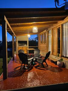 d'une terrasse avec deux chaises, une table et une table. dans l'établissement El Refugio del Lago en Potrero de Garay, à La Estancia