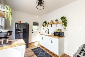 een keuken met witte kasten en een zwarte koelkast bij Jungle House Columbus Downtown Free Parking Sleeps 8 - Near Convention Center & Nationwide Arena - 2BR Luxury Home - Pet Friendly Over 5,800 Five Star Stays in Columbus +59 foto's