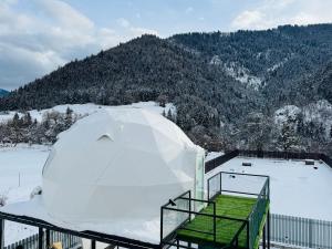 a igloo on a balcony with a snow covered mountain at Buddy glamping Borjomi in Borjomi