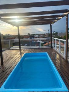 a blue swimming pool on a deck with a view at Casa surf in Guaratuba