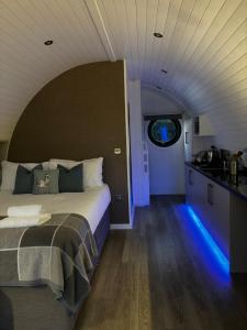 a bedroom with a bed and a kitchen with blue lights at Millview Meadow Retreats in Great Yarmouth