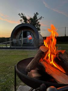 a fire pit with a log on top of it at Millview Meadow Retreats in Great Yarmouth