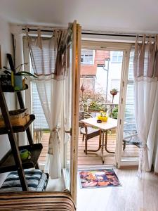 Zimmer mit einer Tür, die auf eine Terrasse mit einem Tisch führt. in der Unterkunft Altstadtzauber Amberg in Amberg