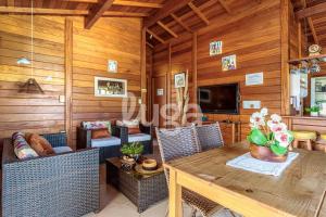 ein Wohnzimmer mit Tisch und Stühlen und einem Fernseher in der Unterkunft Casa Aconchegante – A 200m da praia da Pinheira in Pinheira