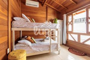 Etagenbett in einem Zimmer mit Holzwänden in der Unterkunft Casa Aconchegante – A 200m da praia da Pinheira in Pinheira