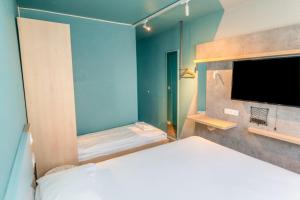 een slaapkamer met een bed en een flatscreen-tv bij Ibis budget Brest Sud Plougastel - Hôtel rénové in Plougastel-Daoulas