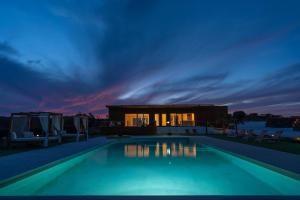 a swimming pool in front of a house at night at Herdade da Yucca - Retreat & Spa in Terena +160 photos