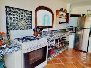 a kitchen with a stove and a sink at Estrella - Casa MoJo's airy 2BR, kitchen, pool in Sayulita